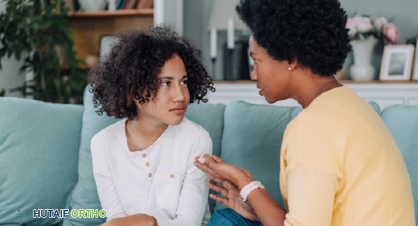طفل مبتسم مع والديه، يظهر الدعم العاطفي والاجتماعي في مواجهة التهاب المفاصل اليفعي