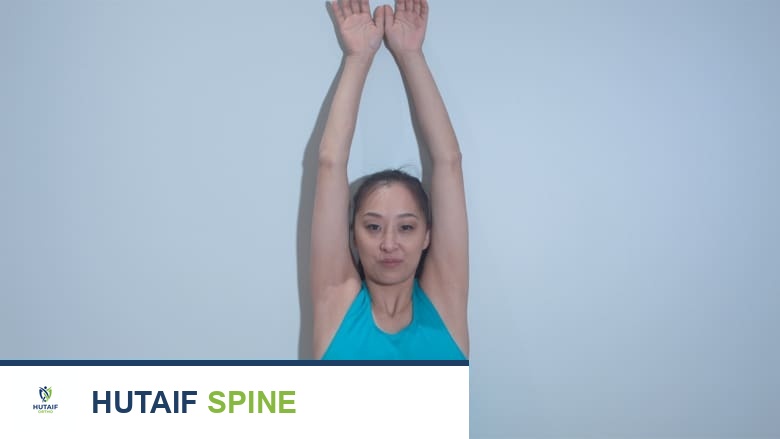 امرأة تؤدي تمرين الانزلاق على الحائط لآلام الرقبة