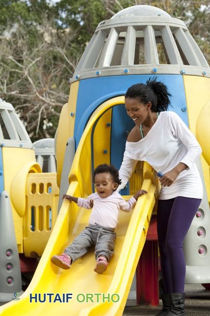 طفل صغير على زلاقة في ملعب